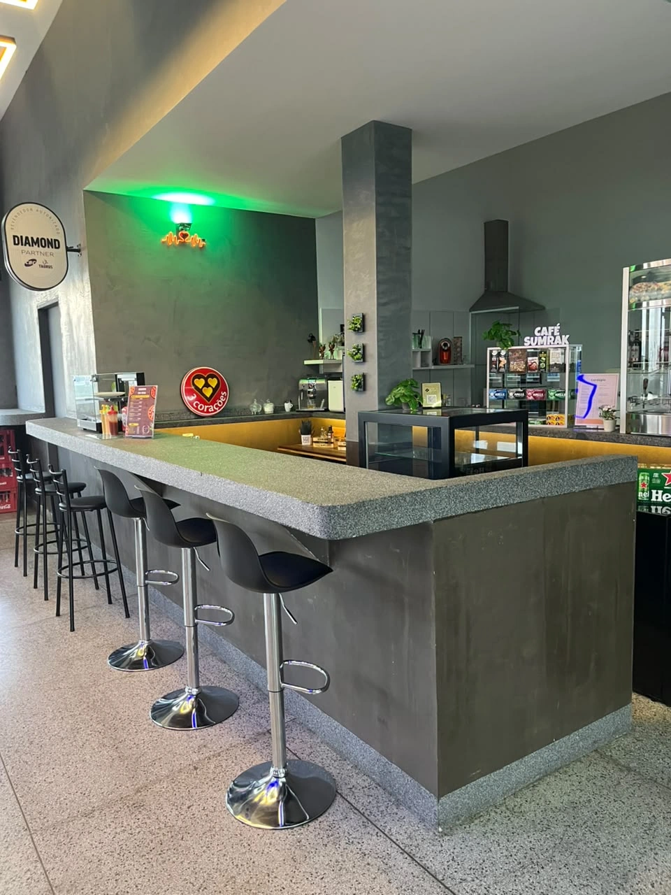 Balcão da cafeteria Sumrak 408 com bancos altos e área de preparo de café