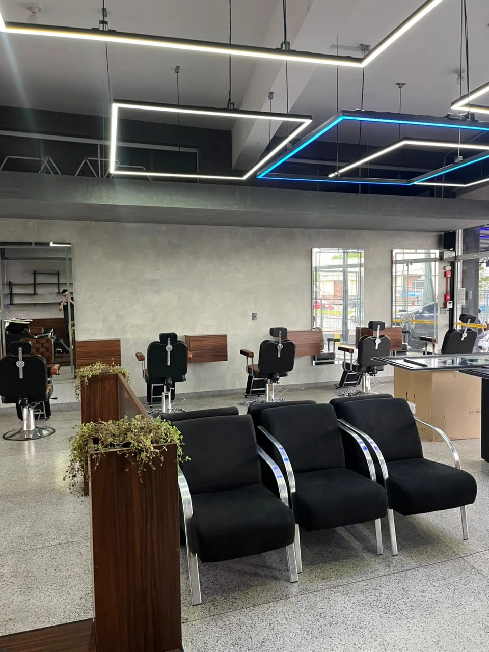 Poltronas de espera e estações do salão da Sumrak 408 sob luminárias brancas e azuis